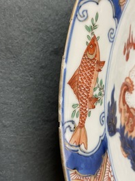 Un plat en porcelaine de Chine famille verte &agrave; d&eacute;cor d'une carpe entour&eacute;e de chevaux et lions bouddhistes, Kangxi